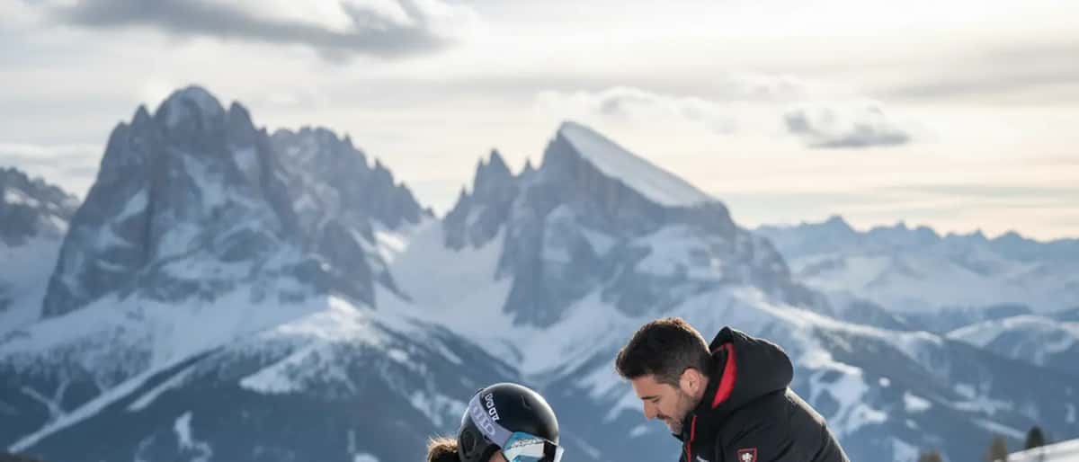 Atleta sciatore con infortunio al ginocchio assistito da un medico sportivo sulla neve