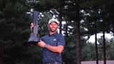 Dustin Johnson champion du LIV Golf Boston, tenant son trophée sur le green