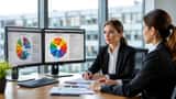 Bewerberin und HR-Manager in Münchner Büro, Horoskop auf Monitor, Bewerbungsunterlagen auf dem Tisch