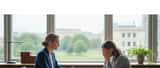 British female solicitor sitting with a distressed client in a calm law office, professional and empathetic setting