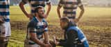 Joueur de rugby recevant des soins médicaux sur le bord du terrain par un médecin du sport