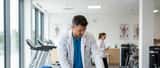 Médico desportivo a examinar jogador de ténis jovem numa clínica de medicina desportiva em Portugal