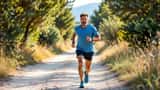 Runner italiano di circa 40 anni che si ferma su un sentiero del parco tenendosi la tibia dolorante dopo una sessione di allenamento
