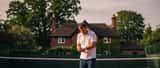 Amateur tennis player holding his wrist on an outdoor tennis court