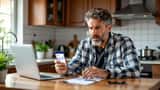 Hombre hispano mirando alarmado su teléfono con una alerta de fraude bancario en la pantalla