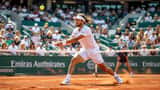 Joueur de tennis professionnel en action sur un court en terre battue