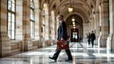 Avocat français avec mallette dans les couloirs en marbre du Palais de Justice de Paris