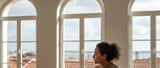 Mulher portuguesa sozinha num apartamento luminoso de Lisboa a refletir após separação