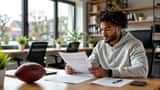 Young professional footballer reviewing a contract document at a London office desk