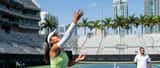Joueuse de tennis en plein service sur un court en dur à Miami sous le soleil