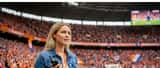 Vrouwelijke journalist met oordoppen in druk stadion