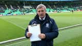 Soccer manager holding tactical clipboard on Championship stadium touchline