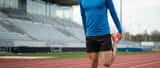 British runner stretching before a sprint session on an athletics track