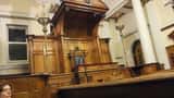 Historic UK courtroom interior with wooden benches and raised judge's bench, representing the double jeopardy law reform