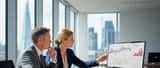 British female financial adviser consulting client at London office with investment charts