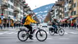 Cycliste en vélo électrique sur une piste cyclable à Berne, Suisse, avec bâtiments suisses en arrière-plan
