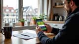 Dansk mand undersøger sportsbetting-app på smartphone ved køkkenbord i København