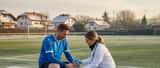 Deutscher Hobbyfußballer auf Amateurplatz bei sportärztlicher Untersuchung am Knie