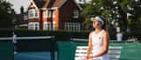 Young female tennis player sitting calmly at changeover, focused and composed on hard court