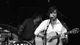 Jack Savoretti performing live on stage, guitar in hand