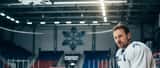 Svensk ishockeyspelare i vit tröja sitter på bänken i Skellefteå Kraft Arena och håller om knäet efter match