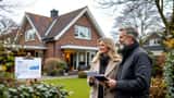 Arkitekttegnet villa i Nordsjælland med Til salg-skilt og par med ejendomsdokumenter