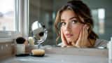Woman examining pale complexion and dark circles in bathroom mirror, hairbrush with shed hair on vanity