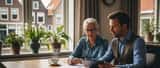 Ouder Nederlands echtpaar bespreekt testament en vermogensplanning met financieel adviseur aan keukentafel
