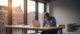 Nederlandse professional uitgeput achter laptop in modern kantoor, burn-out symptomen