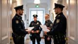 Polizeibeamte zeigen einem Wiener Bewohner einen Durchsuchungsbefehl bei einer Hausdurchsuchung 2026