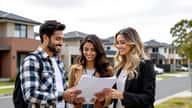Multicultural couple reviewing mortgage documents outside a new townhouse development in Parramatta Western Sydney