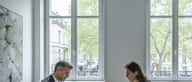 Conseiller financier et cliente examinant des documents patrimoniaux dans un bureau privé à Genève