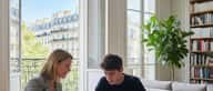 Femme française prenant des notes lors d'un cours d'anglais en visioconférence dans un salon lumineux à Lyon