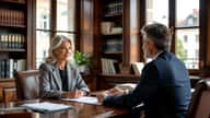 Femme de 58 ans et conseiller en gestion de patrimoine discutant de pension de réversion autour de documents dans un bureau strasbourgeois