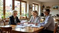 Energieberaterin und Hausbesitzer prüfen BEG-Förderunterlagen und Sanierungsplan am Esstisch in einem Stuttgarter Einfamilienhaus