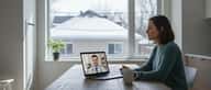 Femme québécoise consultant un médecin en ligne depuis sa cuisine, laptop ouvert avec vidéoconsultation, lumière hivernale