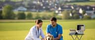 Dansk dyrlæge undersøger en golden retriever på et undersøgelsesbord i en moderne dyreklinik om aftenen
