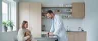 Kvinde med kat hos dyrlæge under konsultation i dansk klinik
