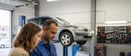 Mecânico português a explicar diagnóstico automóvel a cliente numa oficina em Lisboa