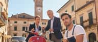 Cliente italiano che consegna le chiavi dell'auto a un meccanico in un'officina illuminata dalla luce del sole
