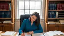 Professional woman reviewing Connecticut employment law documents at a desk in a Stamford home office, overcast natural light