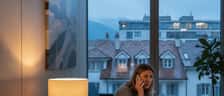 Femme suisse inquiète appelant un médecin de garde depuis son salon à Lausanne en soirée