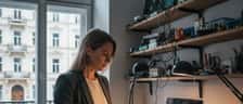 Frau untersucht Laptop mit gebrochenem Display in einer Wiener Reparaturwerkstatt
