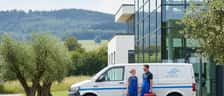 Mekaniker utfører AC-service på en bil i et moderne norsk verksted med servicemaskin og slanger