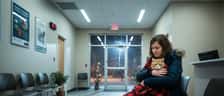 Femme tenant un chat dans une salle d'attente de clinique vétérinaire d'urgence au Québec la nuit