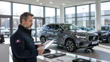 Couple examinant les fiches techniques et le barème du malus automobile dans un concessionnaire français