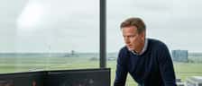 Nederlandse ondernemer bekijkt beveiligingsmelding op computerscherm in modern kantoor