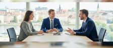 Finanzberater und Kundin besprechen transparente Honorarunterlagen an einem Schreibtisch in Frankfurt