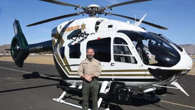 Sheriff Chad Bianco standing with Riverside County Sheriff helicopter