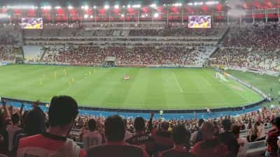 Vista panorâmica de estádio durante partida da Copa Libertadores com adeptos nas bancadas